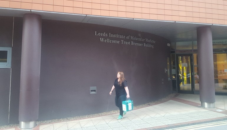 Angie transports the protective bag containing a tissue sample back to the lab